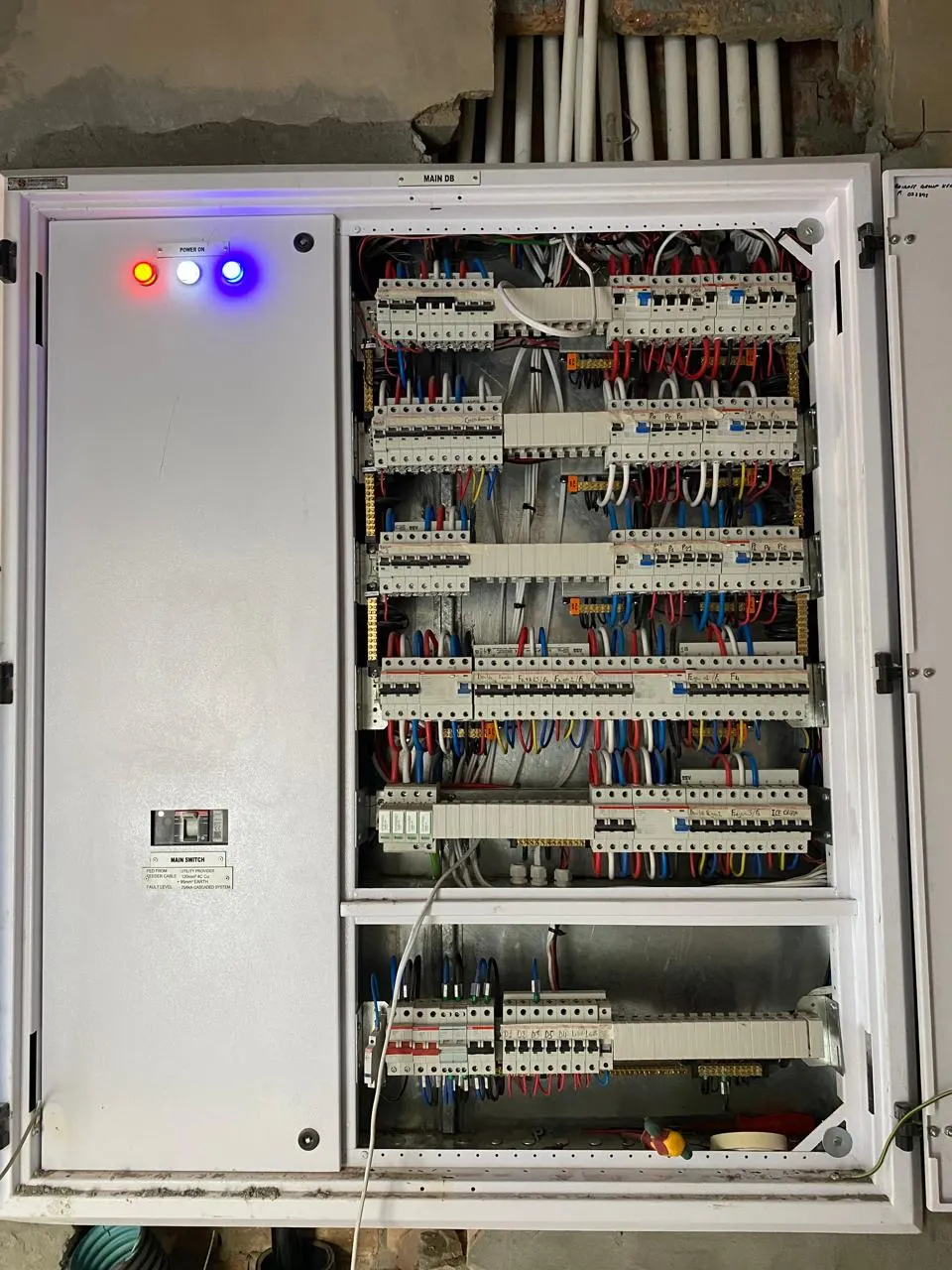Open distribution board with rows of circuit breakers and neatly dressed wiring